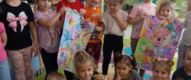 Dzień Pluszowego Misia - dzieci pozują do zdjęcia z maskotkami i kolorowankami misiów