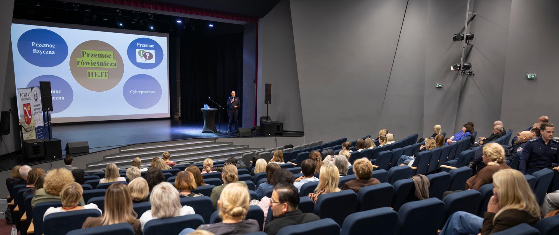 Uczestnicy konferencji w Centrum Kultury i Wypoczynku w Proszowicach podczas spotkania, na scenie jeden z prelegentów