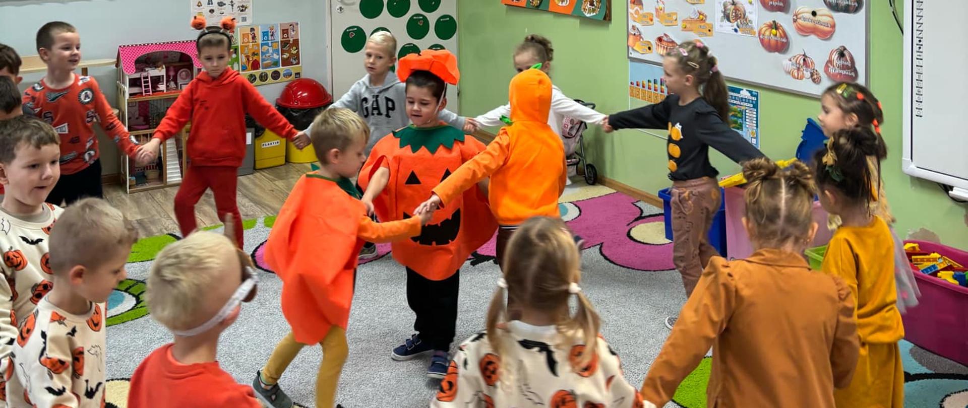 Dzieci ubrane na pomarańczowo podczas zabaw z okazji Dnia Dyni