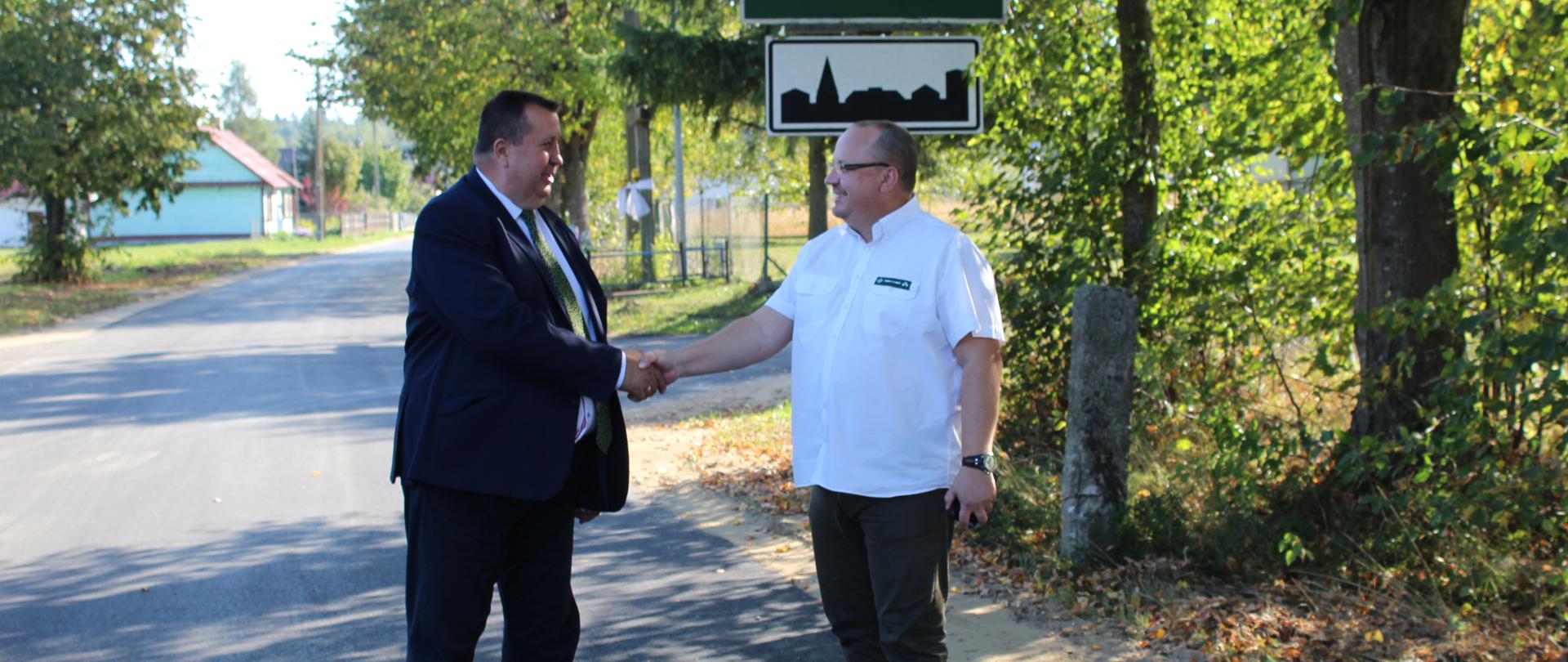 Dyrektor Zarządu Dróg Powiatowych Mikołaj Janowski i Nadleśniczy Nadleśnictwa Hajnówka ściskają sobie dłoń w geście podziękowania za współpracę