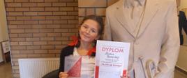 Maria pozuje z dyplomem i statuetką