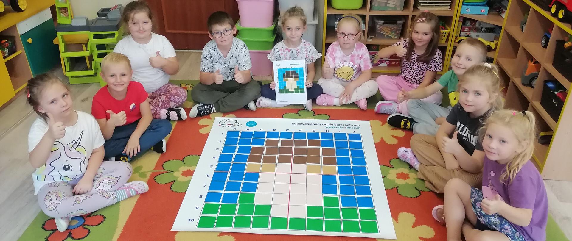 10 Dzieci siedzi wokół maty przedstawiającej grzybka 