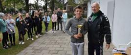 Starsi sportowcy odbierają puchary od organizatora