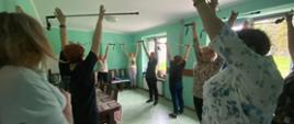 seniorzy ćwiczący z kijkami