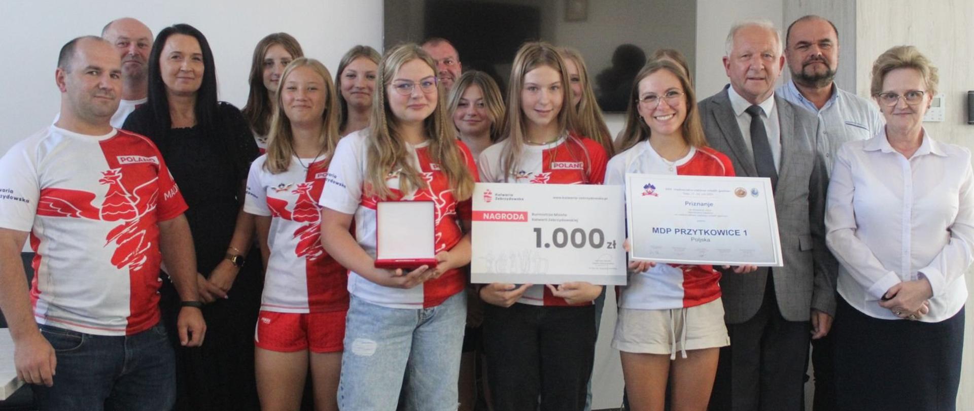 Zdjęcie grupowe na pierwszym planie dziewczęta z Młodzieżowej Drużyny Pożarniczej Dziewcząt z OSP Przytkowic