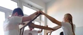 Podczas warsztatów tkackich - młodzież ustawia sprzęt