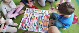 Dzieci w trakcie układania puzzli z kolorowanek o tematyce Dnia Kolorowej Skarpetki