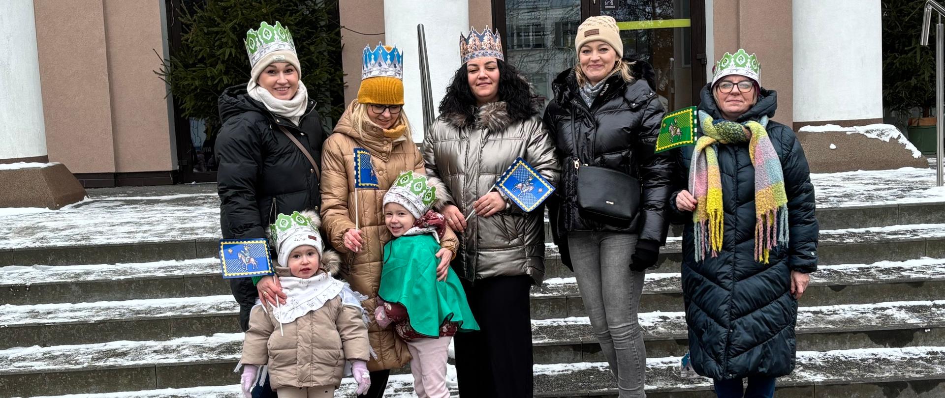 5 kobiet i 2 dzieci przed budynkiem