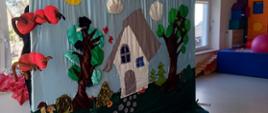 Scenografia teatrzyku - na tkaninie namalowany dom i drzewa
