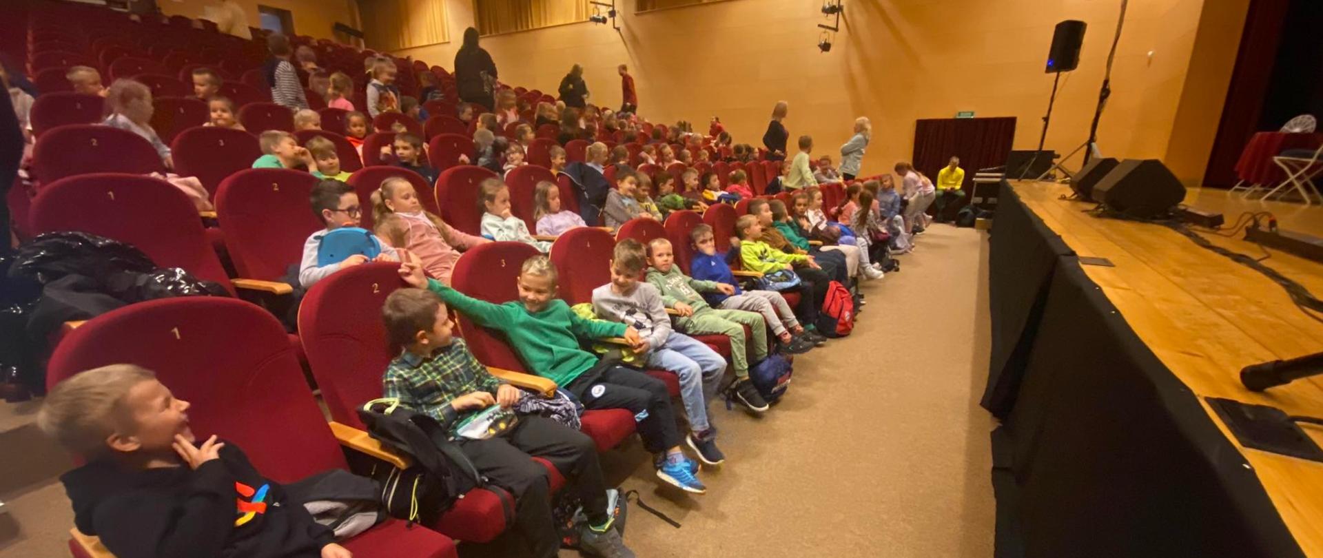 Uczniowie klas młodszych zasiadają na widowni Orawskiego Centrum kultury, gdzie uczestniczą w spektaklu "Piękna i Bestia".