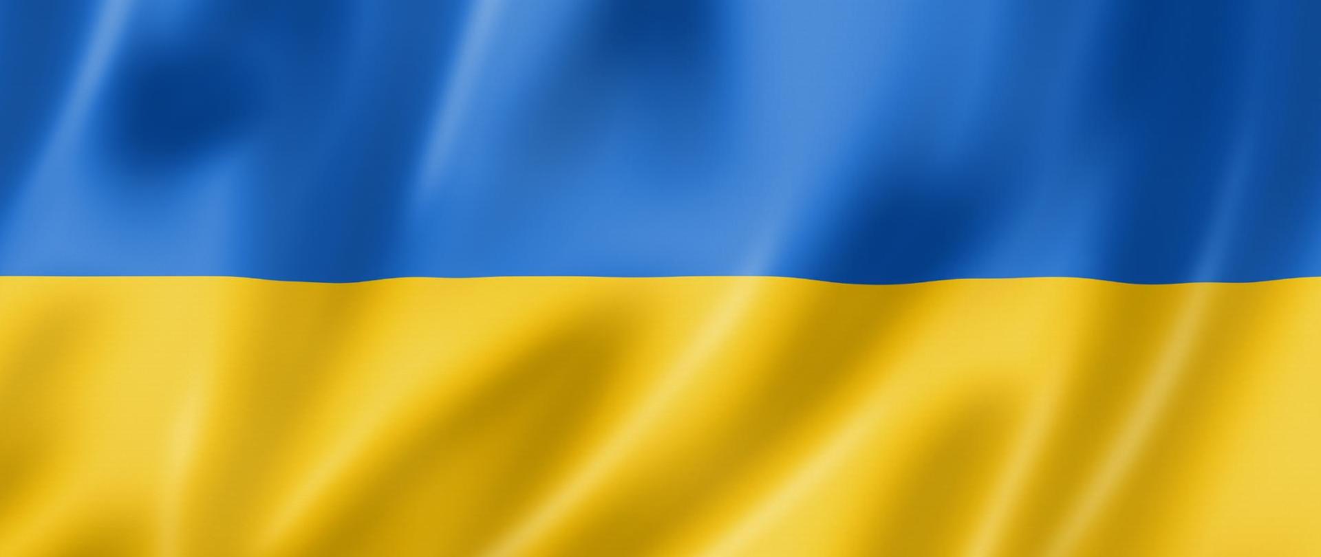 Zdjęcie przedstawia flagę Ukrainy. Flaga jest dwu kolorowa. Od góry do połowy jest kolor niebieski, druga połowa flagi jest w kolorze żółtym.