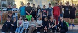Uczniowie pozują do wspólnego zdjęcia na tle topografii miasta