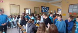 Uczniowie klasy 4 uczą się mnożyć na palcach przy stolikach edukacyjnych prowadzonych przez uczennice klasy 8a.