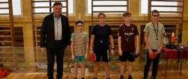 Dekoracja zawodników - czworo młodych uczestników turnieju stoi z medalami, obok Dyrektor OSiR