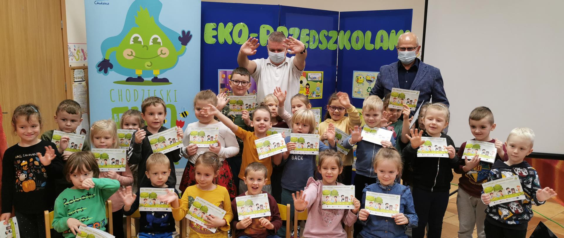 Dzieci, moderator i burmistrz Chodzieży prowadzący zajęcia edukacyjne w przedszkolu 