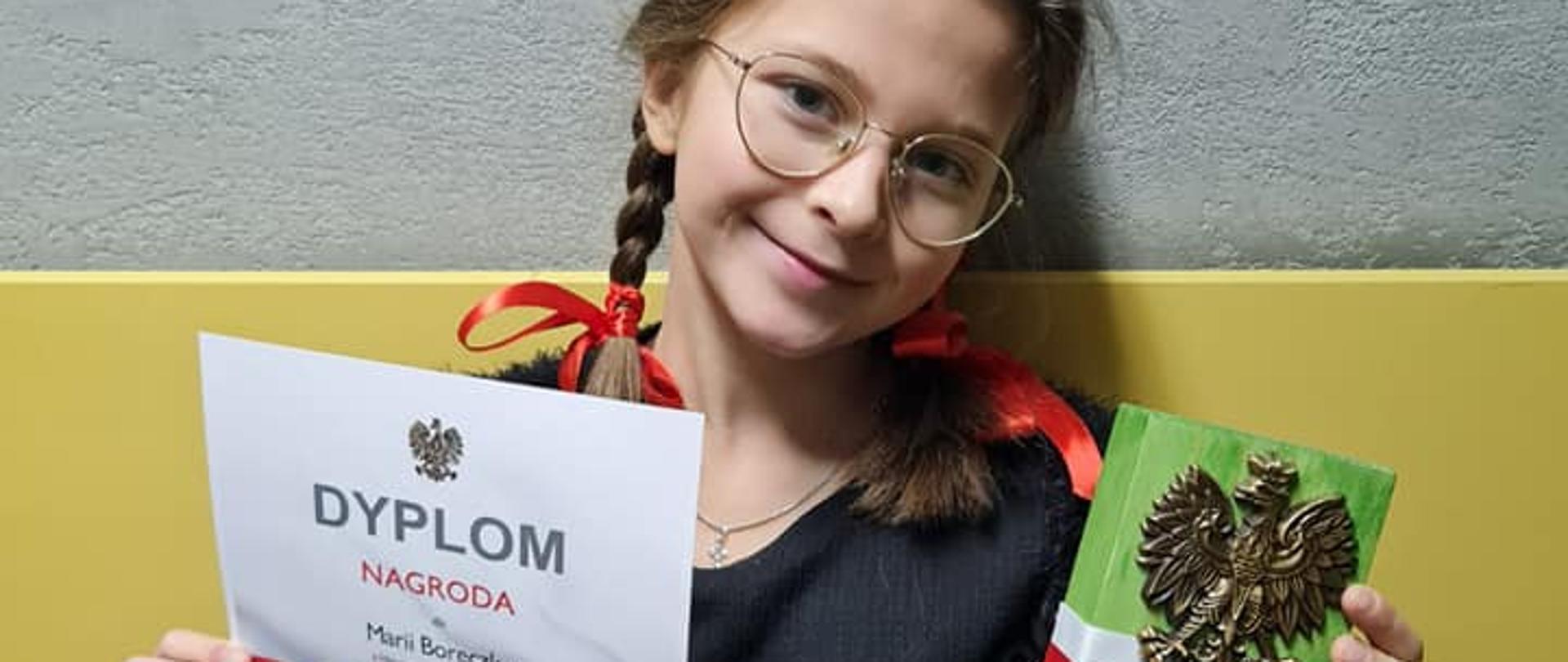 Marysia prezentuje dyplom i statuetkę