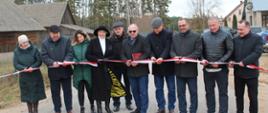 Uroczyste otwarcie drogi - uczestnicy przecinają wstęgę