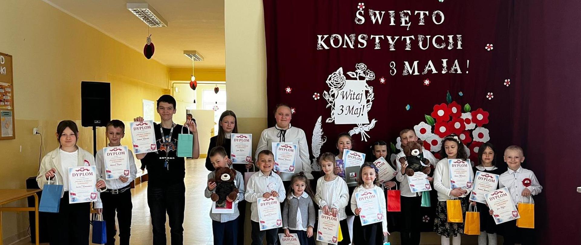 Nagrodzeni w konkursie uczniowie trzymają w ręku nagrody i dyplomy