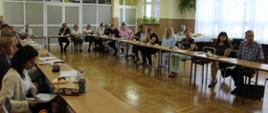 Nauczyciele biorący udział w szkoleniu siedzą przy stole