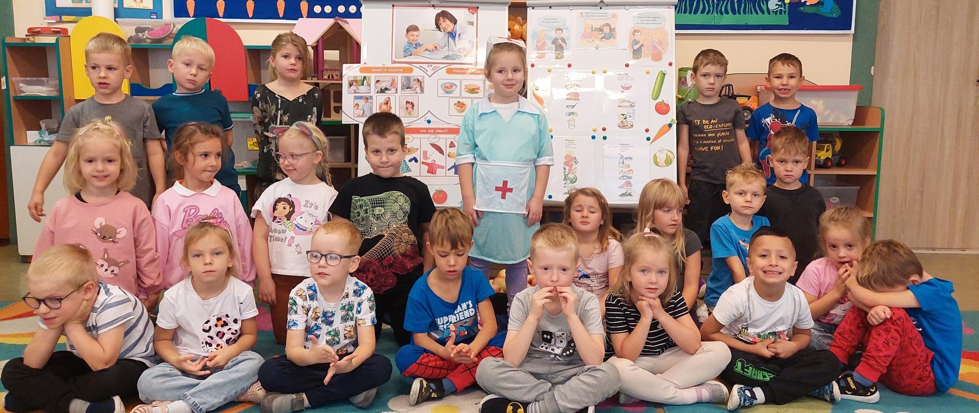 Grupa dzieci , dziewczynka przebrana za pielęgniarkę