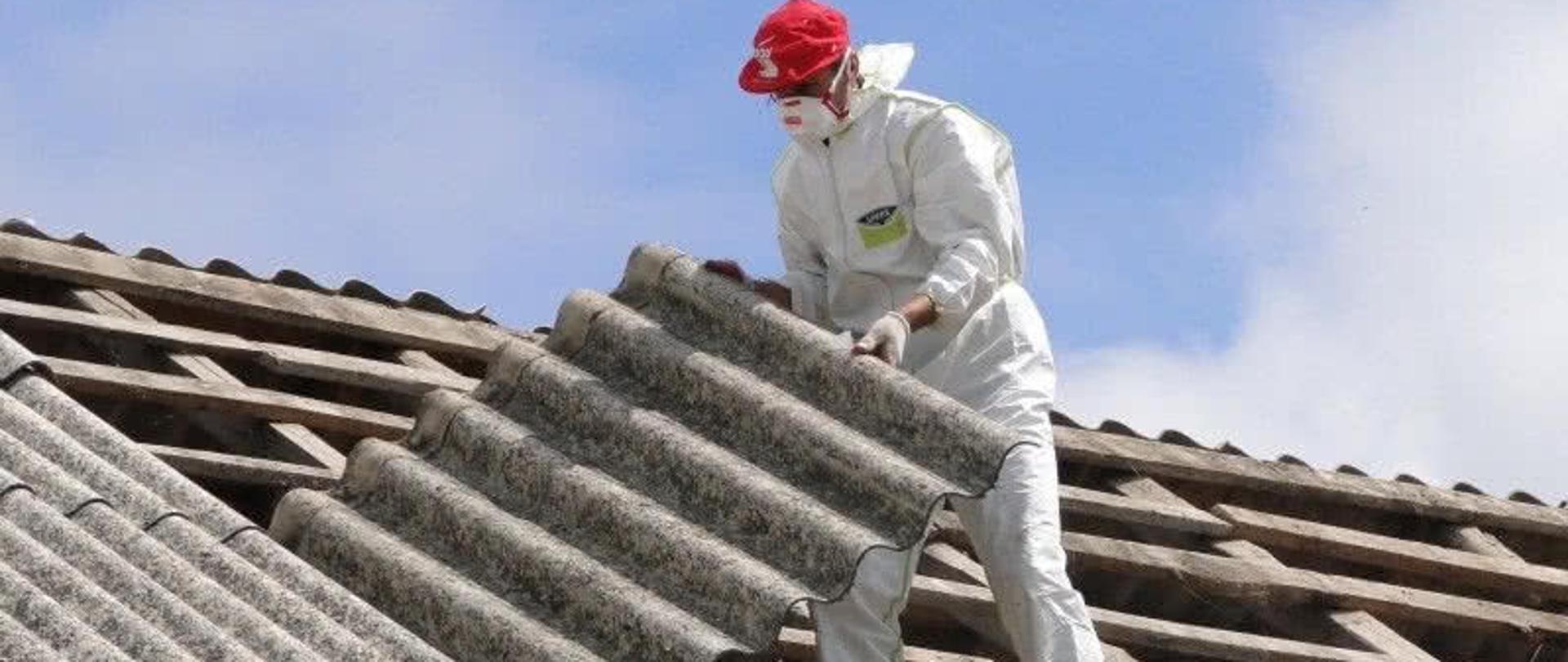 człowiek usuwający azbest z dachu domu