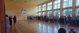 Uczniowie zebrani na sali gimnastycznej wysłuchują pogadanek pedagoga i psychologa