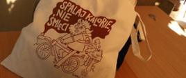Torba bawełniana z logo kampanii, w tle prowadząca zajęcia