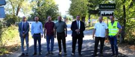 Uczestnicy odbioru drogi pozują przy znaku Postołowo