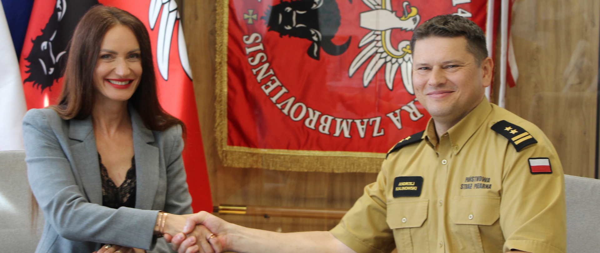 Starosta Zambrowski Edyta Marchelska-Groszfeld oraz Komendant Powiatowy Państwowej Straży Pożarnej w Zambrowie bryg. Andrzej Kalinowski podają sobie rękę.