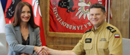 Starosta Zambrowski Edyta Marchelska-Groszfeld oraz Komendant Powiatowy Państwowej Straży Pożarnej w Zambrowie bryg. Andrzej Kalinowski podają sobie rękę.