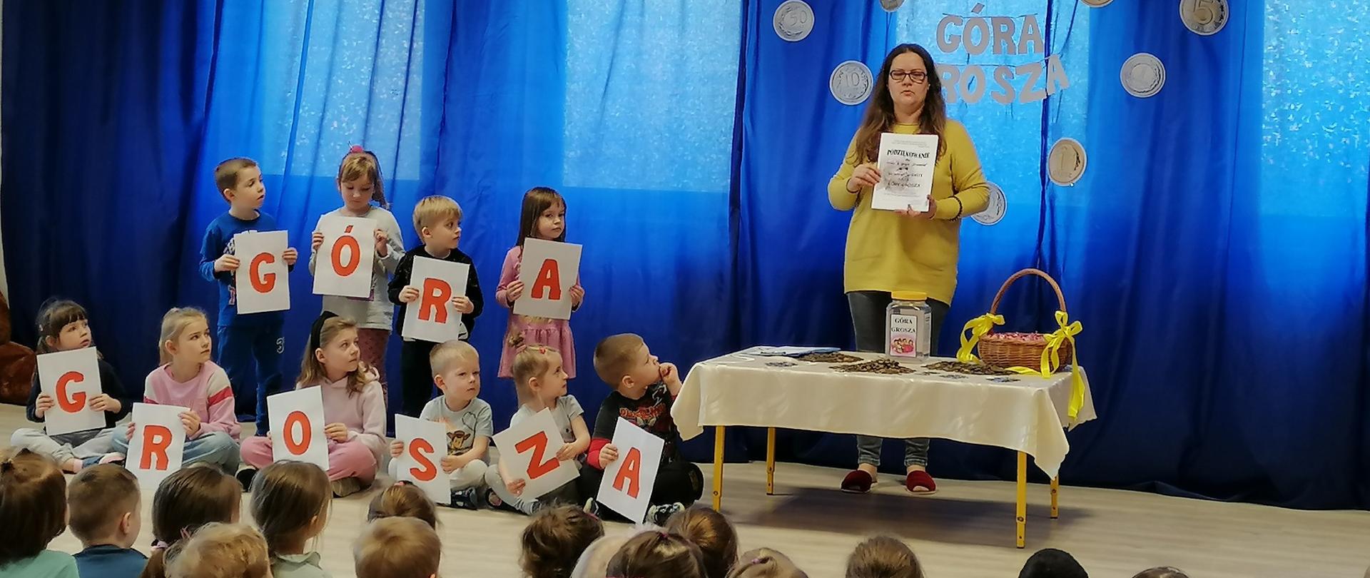 Dzieci z napisem GÓRA GROSZA i nauczycielka 