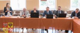 kilka osób siedzi przy stole konferencyjnym