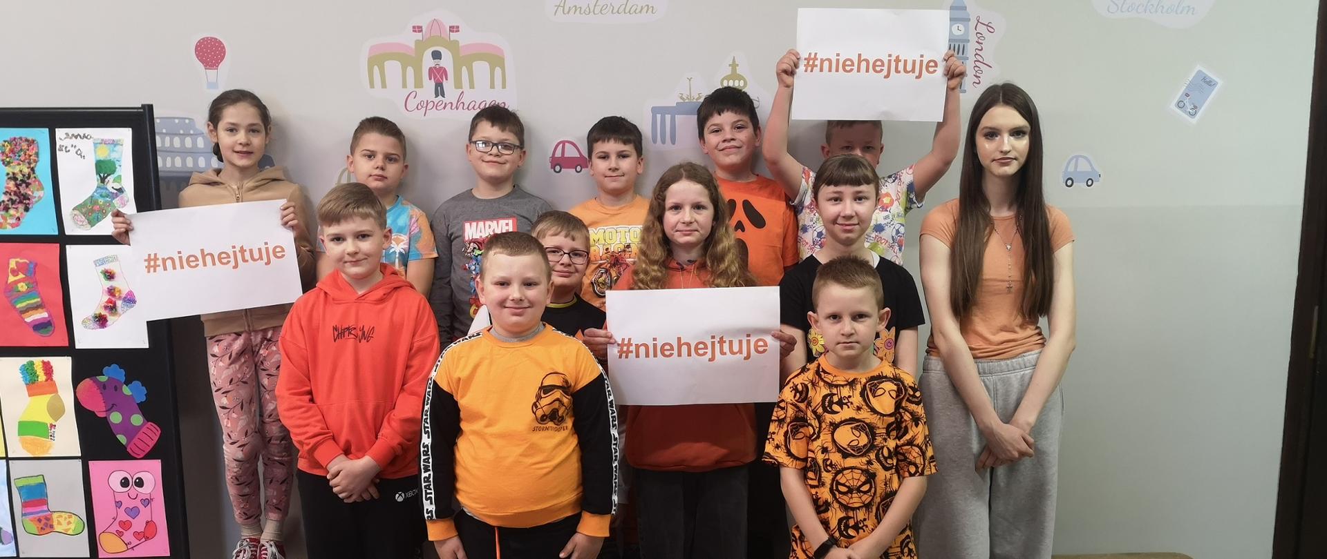 Zdjęcie grupowe uczniów w pomarańczowych koszulkach