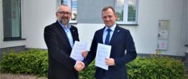 Samorząd Powiatu Przasnyskiego organizację tegorocznych dożynek powierzył Gminie Krasne. Na zdjęciu Starosta Przasnyski wraz z Wójtem Gminy Krasne uściskują sobie dłonie trzymając egzemplarze zawartej umowy.