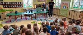 Grupa dzieci obserwuje eksperymenty wykonywane przez animatora 