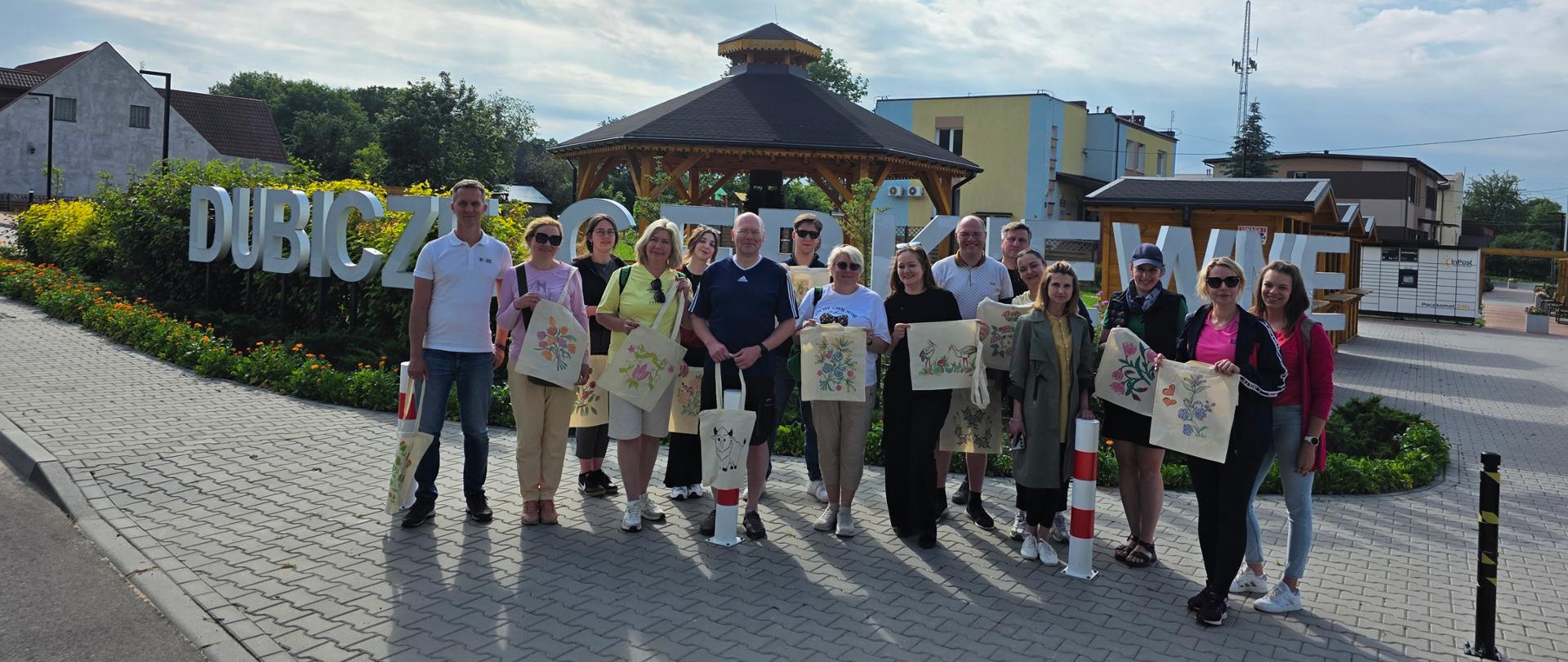 Uczestnicy spotkania pozują przed napisem "Dubicze Cerkiewne" 