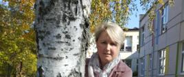 Dzieci i nauczycielki przytulają się do drzewa
