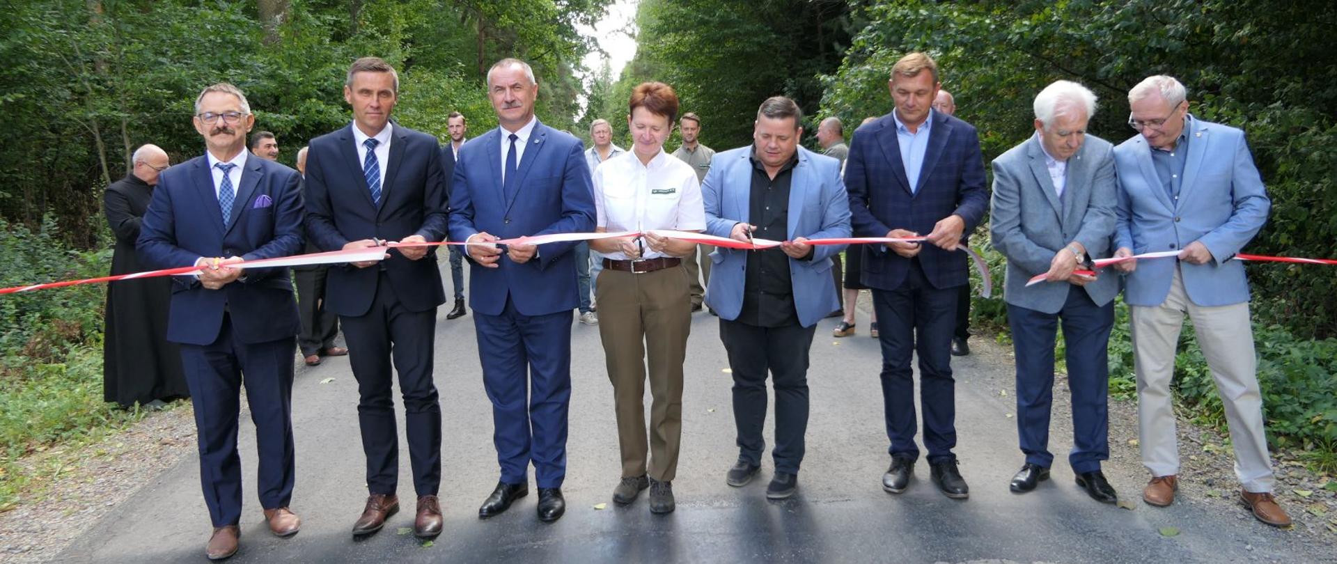 Uczestnicy uroczystości dokonują symbolicznego otwarcia drogi poprzez przecięcie szarfy.