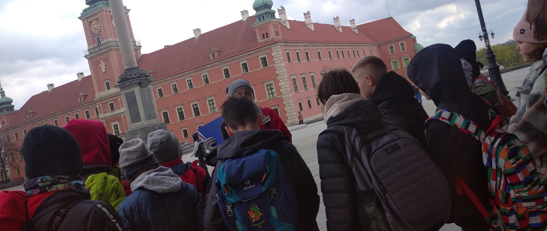 Dzieci na tle dużego czerwonego budynku