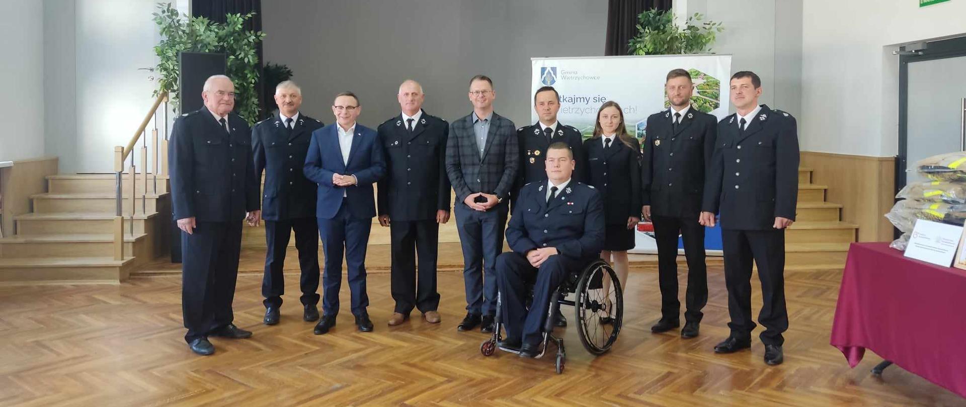 zdjęcie przedstawia kobietę i mężczyzn w wieku od 25 do 75 lat, ubranych w mundury galowe pozujących do wspólnego zdjęcia