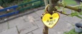 Złota kłódka w kształcie serca z wygrawerowaną na niej koroną i napisem "Klasa 8 2025"