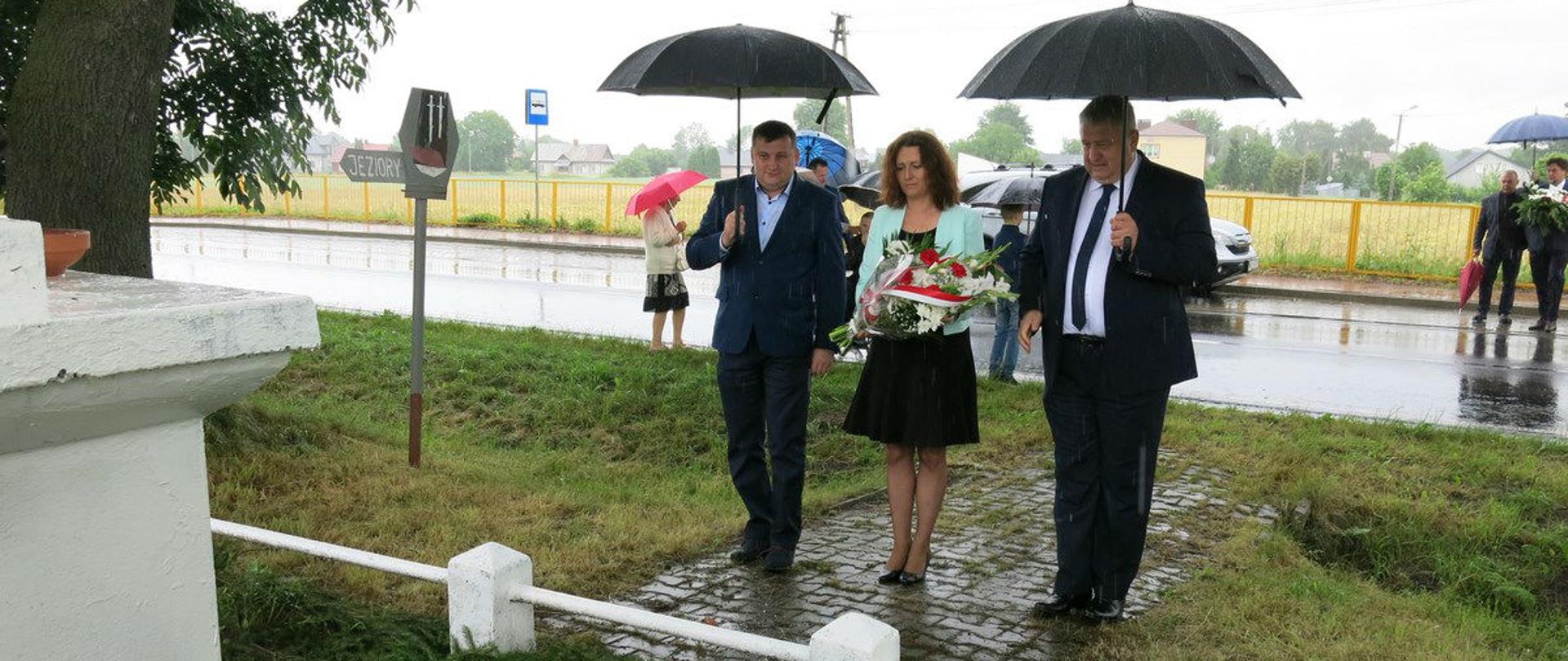 Wicestarosta Powiatu Łosickiego Michał Michaluk, Wiceprzewodnicząca Rady Powiatu Łosickiego Urszula Sadowska oraz Starosta Powiatu Łosickiego Janusz Kobyliński składający kwiaty pod pomnikiem pomordowanych mieszkańców Chotycz.