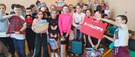 Uczniowie zamiast plecaków przynieśli książki i przybory szkolne w innych pojemnikach, takich jak kosz wiklinowy, kosz na śmieci, walizka, pojemnik na narzędzia i inne