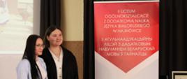 Uczennice II LO pozują do zdjęcia na tle rollup promującego szkołę