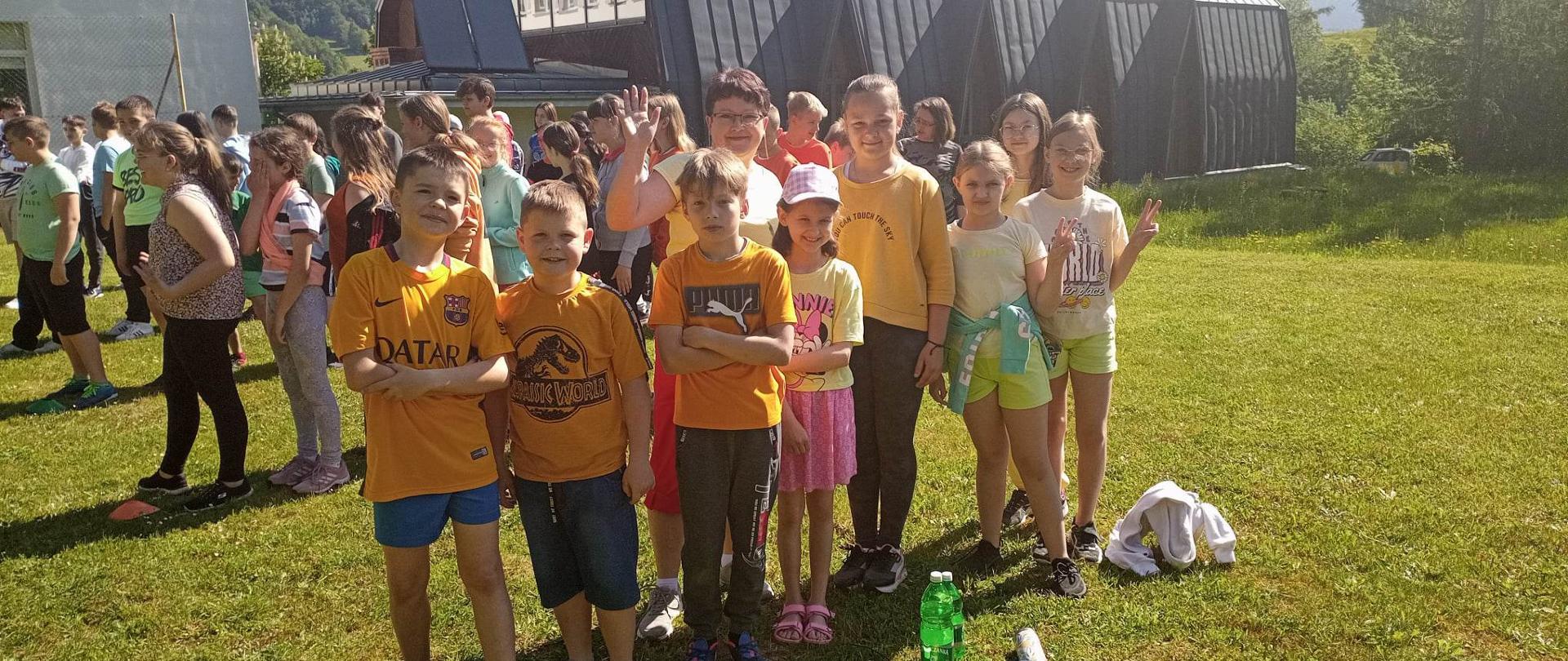 Uczniowie na szkolnym boisku czekają na konkurencje sportowe