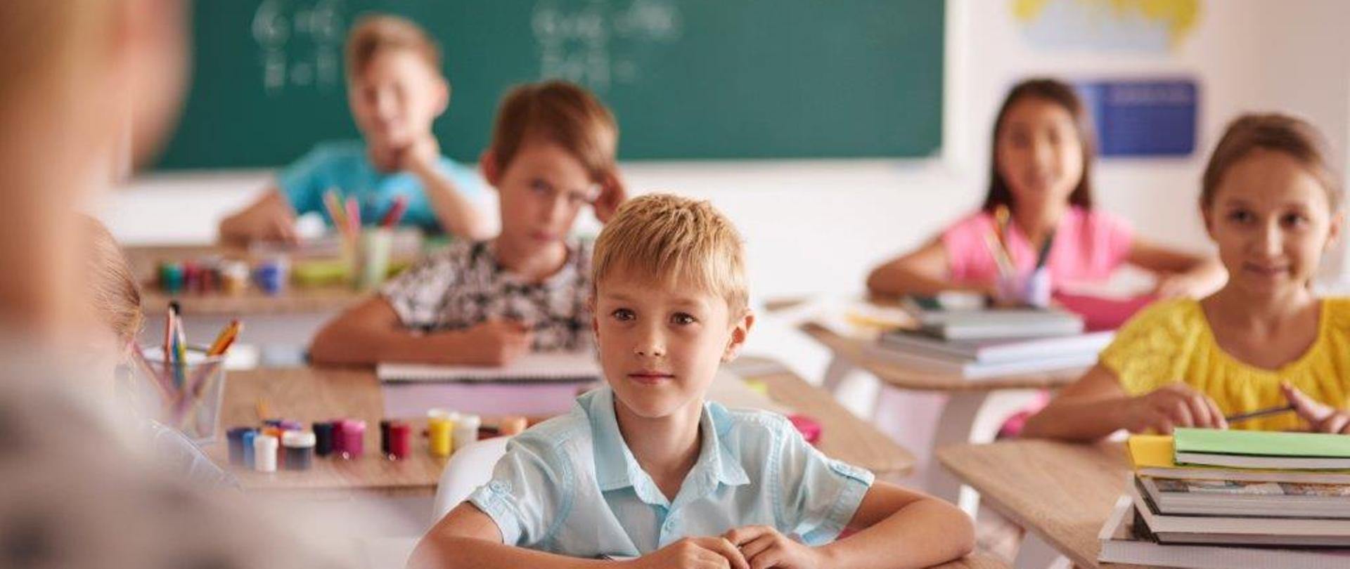 grafika przedstawia dzieci podczas lekcji