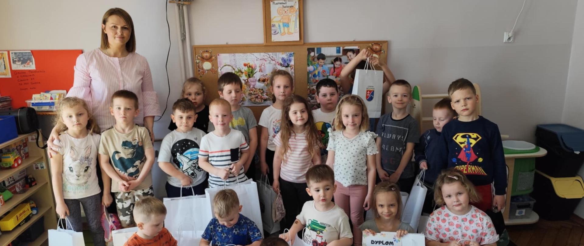 dzieci stoją z nagrodami i dyplomami