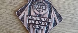 Brązowy medal w kształcie rombu z napisem "Tarnobrzeg 20-22.03.2026", na biało-czerwonej wstążce
