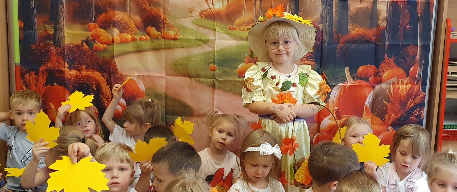 1 dziewczynka przebrana za Panią Jesień i grupa dzieci