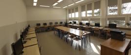 Zdjęcie przedstawia pracownię komputerową wyposażoną w nowoczesne zastawy komputerowe wraz z drukarką sieciową.